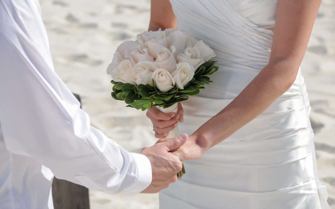 wedding couple holding hands on the beach