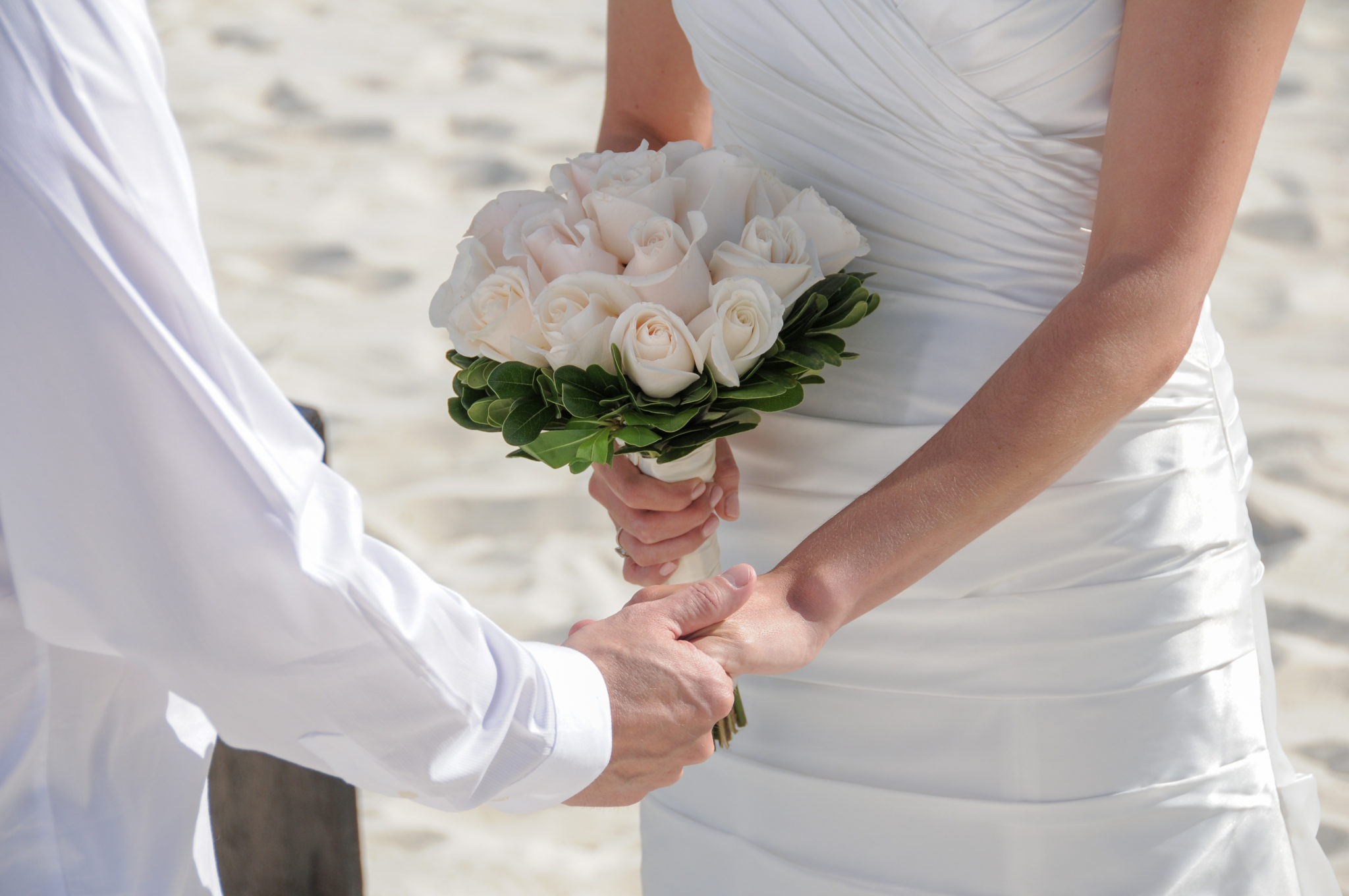 wedding couple holding hands on the beach wedding couple holding hands on the beach