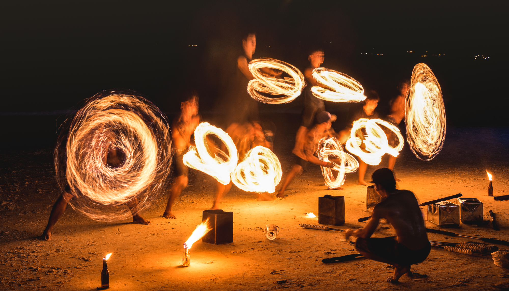 Group of fires dancers performing amazing fire show with sparkles at night for wedding reception entertainment.