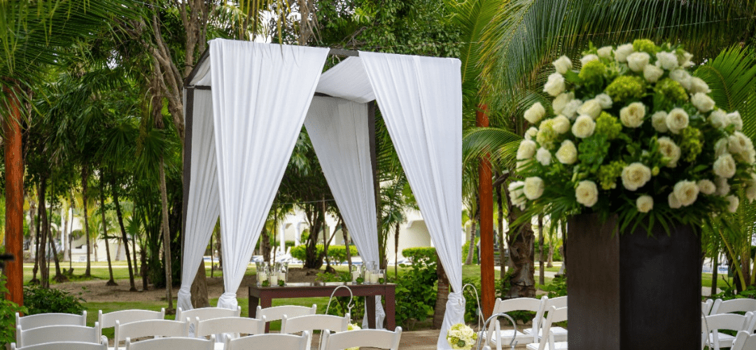 Enchanted Orchid Garden at El Dorado Royale featuring a small wedding ceremony set up with tropical trees in the background