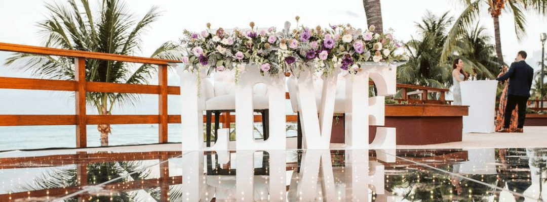 Love block letters with flowers on top set up on the terrace at Grand Fiesta Americana Coral Beach for a wedding reception