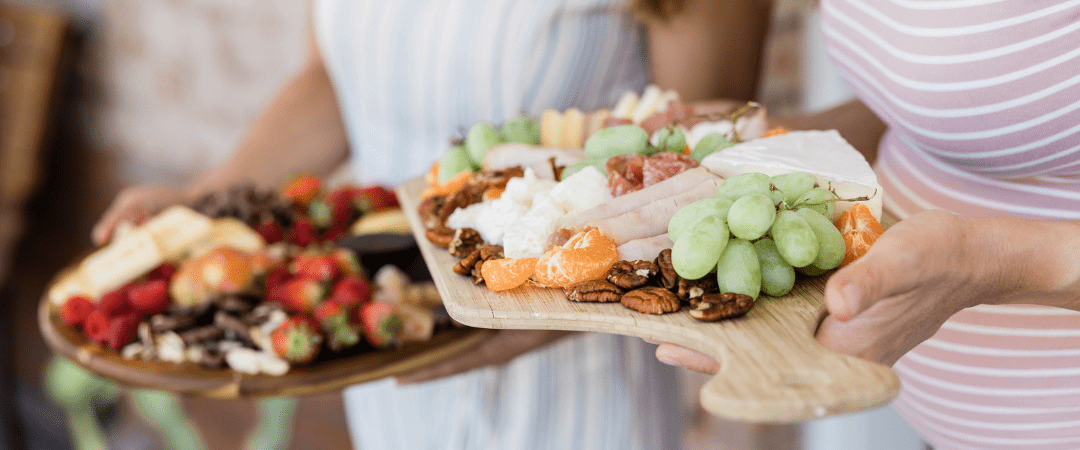 A zoomed in photo of two people holding charcuterie boards
