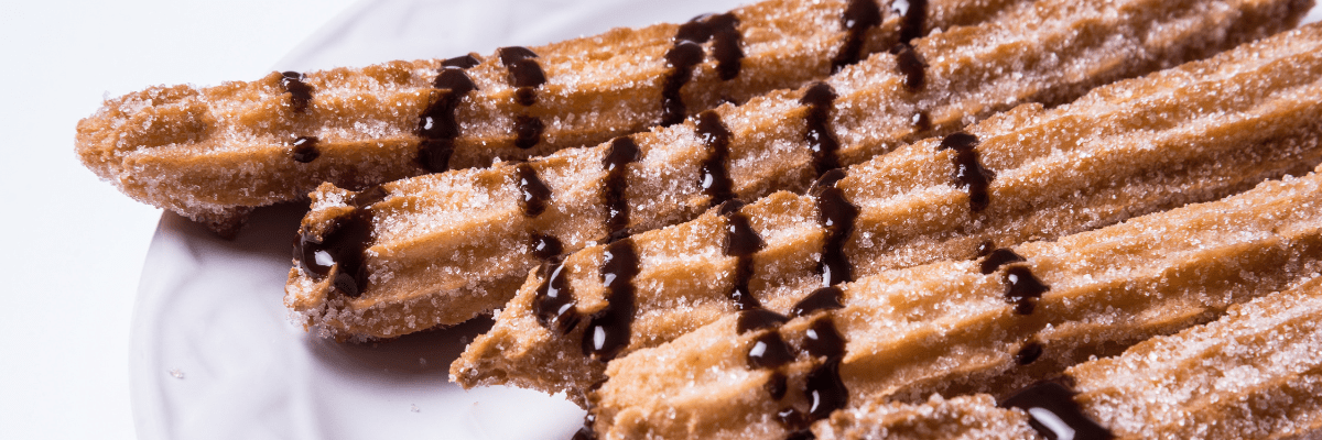 Cinnamon churros with a chocolate drizzle for a wedding dessert