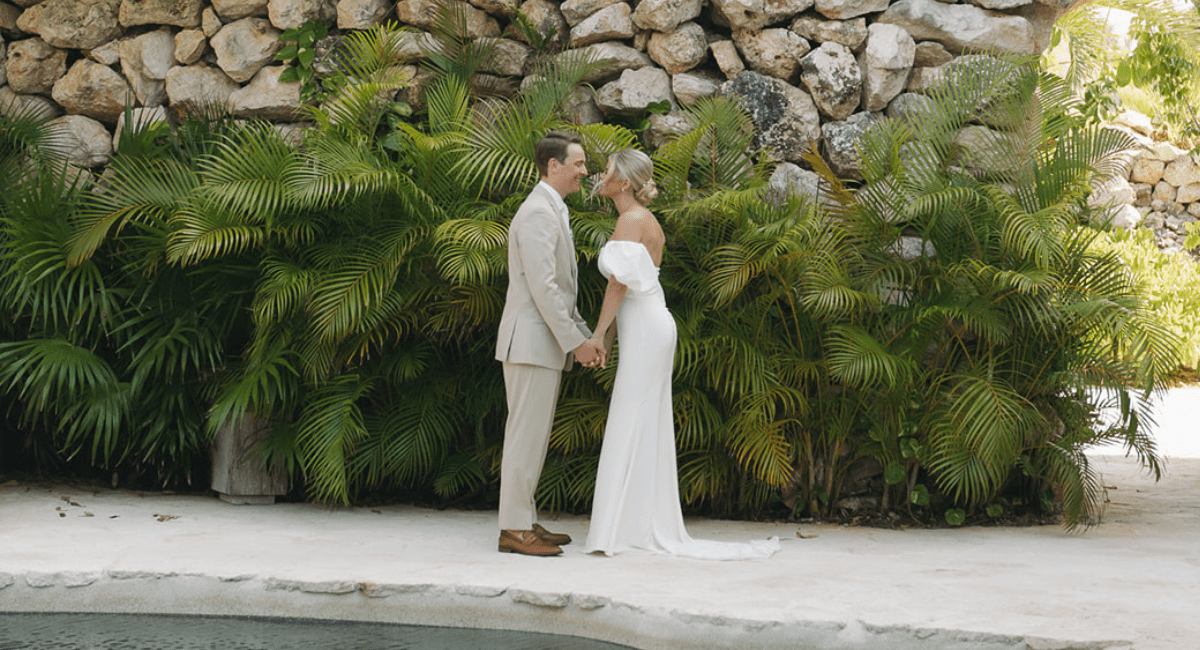 Bride and groom holding hands, facing each other at their destination wedding they budgeted for