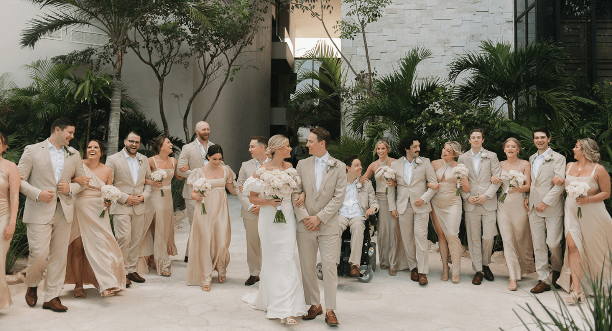 Wedding party standing in a line behind the happy bride and groom at their destination wedding