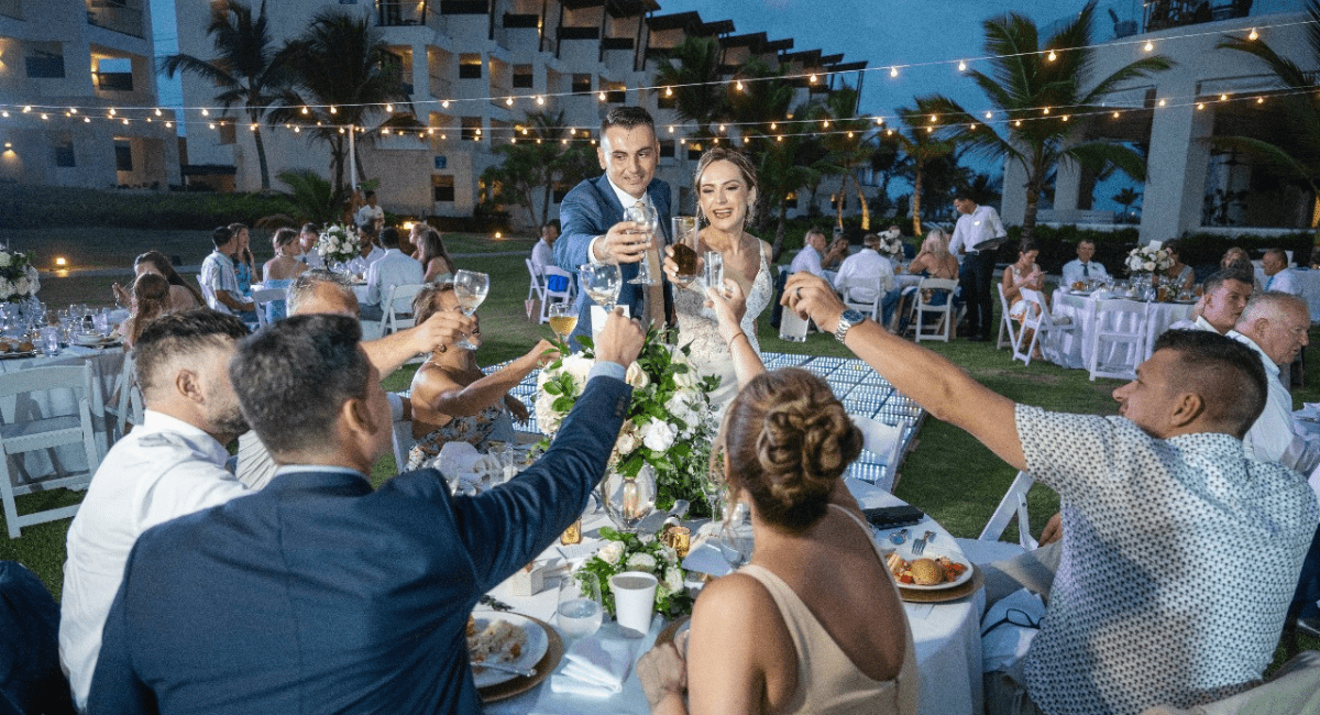 Wedding couple cheersing at a table of their guests at their all-inclusive destination wedding ceremony
