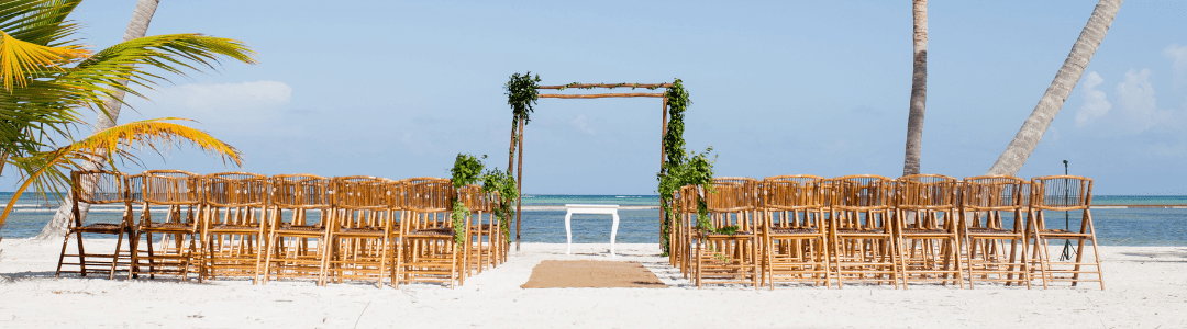 Destination wedding beach ceremony setup with beautiful ocean backdrop